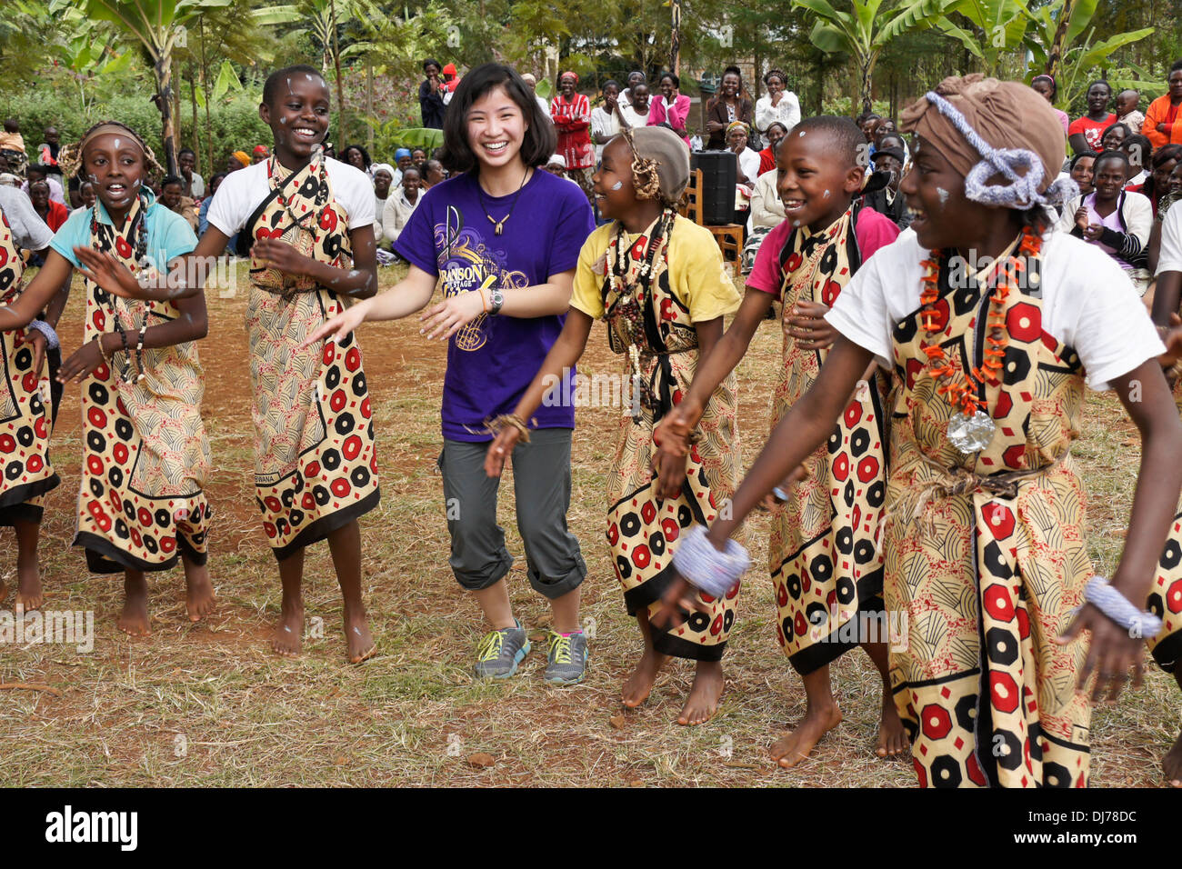 Kikuyu Mädchen tanzen mit chinesisch-amerikanische Mädchen (Tourist), Karatina, Kenia Stockfoto