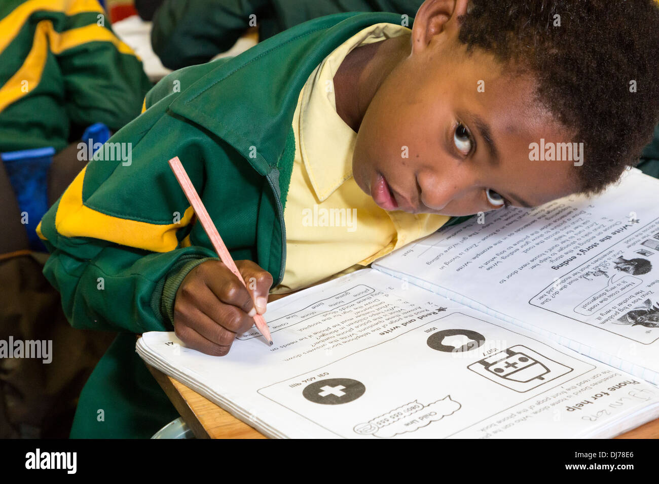 Südafrika, Cape Town, Guguletu Township. Junger Student Arbeit in Arbeitsmappe, in englischer Sprache. Intshinga-Grundschule. Stockfoto