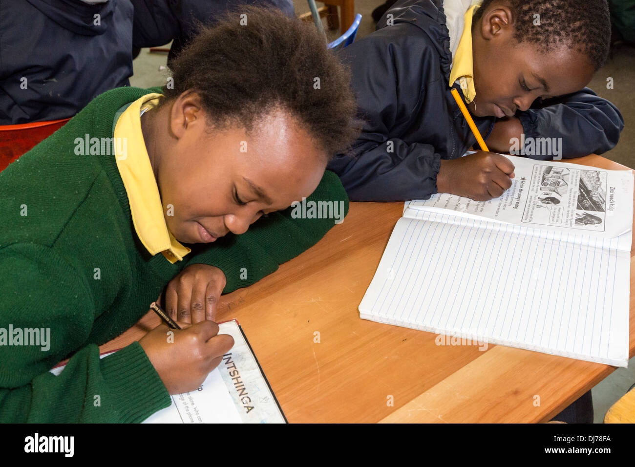 Südafrika, Cape Town, Guguletu Township. Studenten arbeiten in ihren Arbeitsmappen in englischer Sprache. Intshinga-Grundschule. Stockfoto