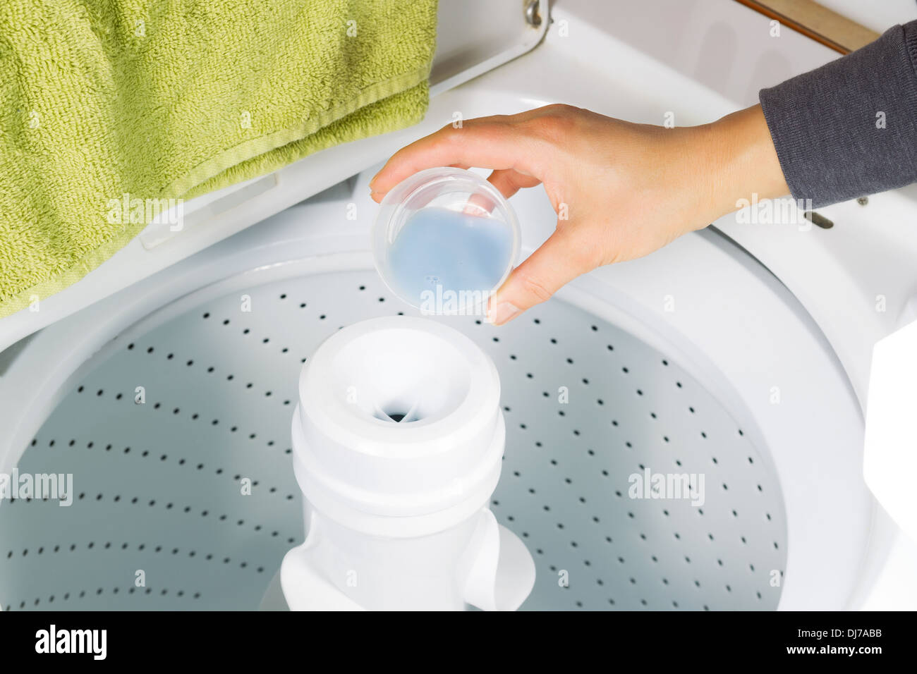 Horizontale Foto weibliche Hand, Flüssigseife in die Waschmaschine für die Wäsche Stockfoto