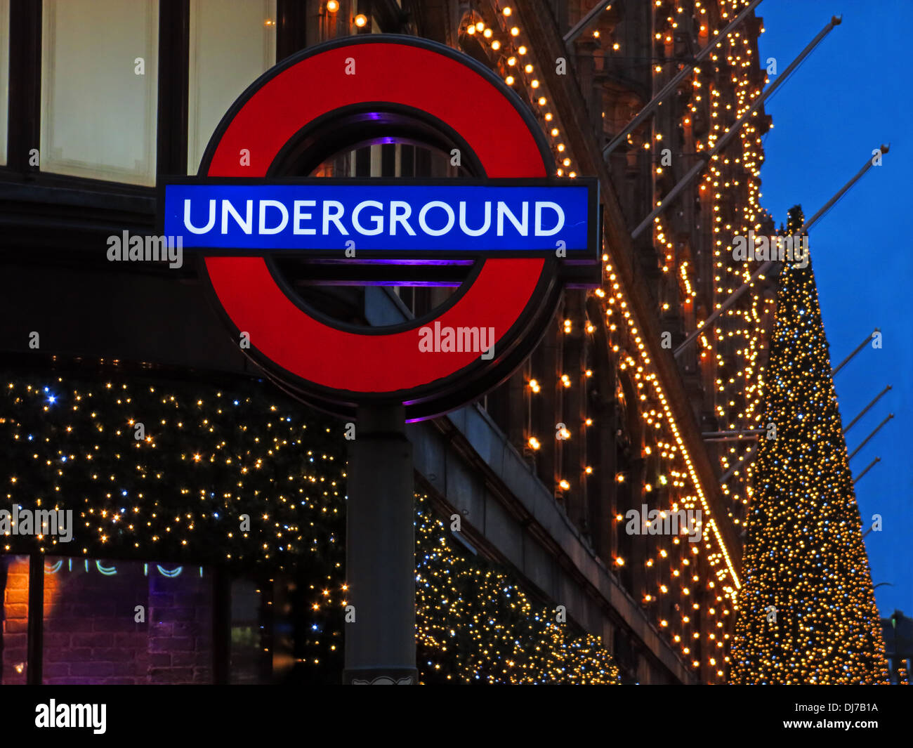 Londoner U-Bahn Zeichen bei Harrods Knightsbridge Brompton Road, West London, England, UK in der Abenddämmerung Stockfoto
