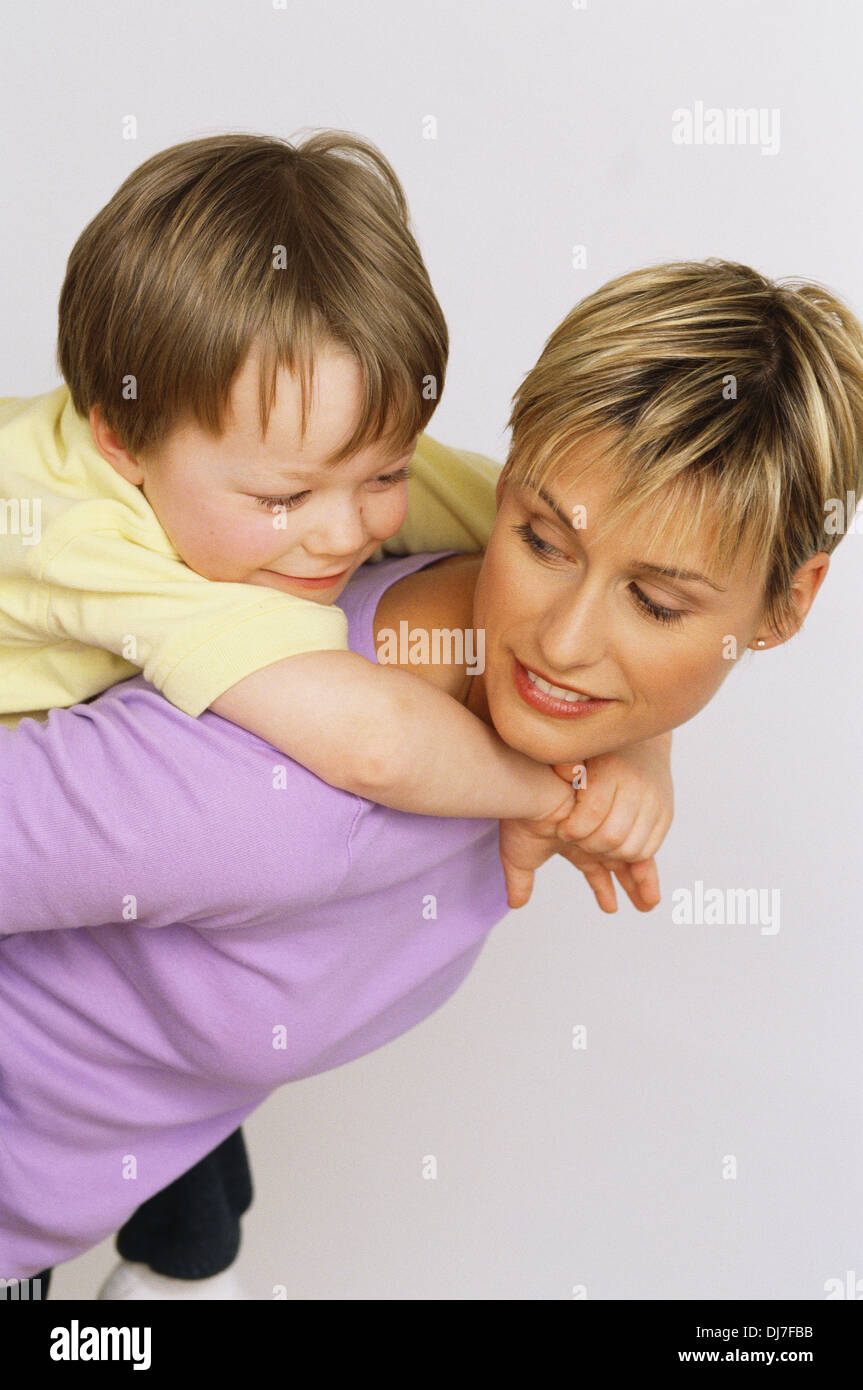 Mutter und Sohn Huckepack Fahrt Stockfoto