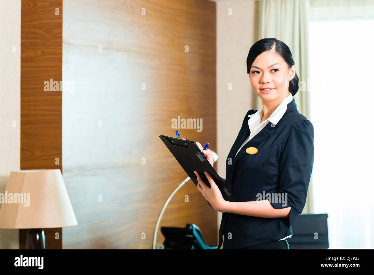 Housekeeping Manager oder Assistent Kontrolle oder Überprüfung der Zimmer oder Anzug eines Hotels mit einer Checkliste auf Sauberkeit Stockfoto