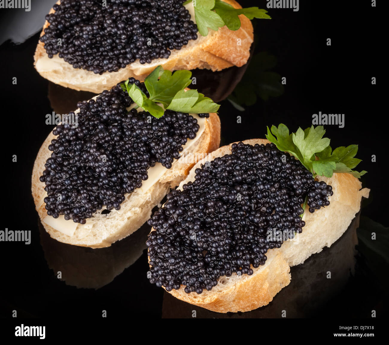 Kleine Sandwiches mit schwarzem Kaviar auf dunkle Platte Stockfoto