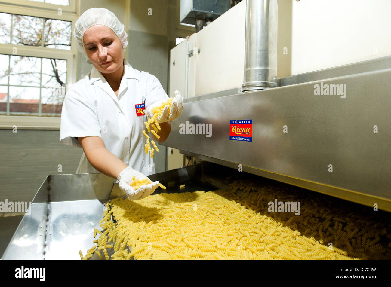 Riesa, Deutschland. 18. November 2013. Marketingmanager von Pasta-Hersteller steht Riesa GmbH Laura Kny überprüft die Qualität der Spirelli in der Fabrik in Riesa, Deutschland, 18. November 2013. Foto: SEBASTIAN KAHNERT/Dpa/Alamy Live News Stockfoto