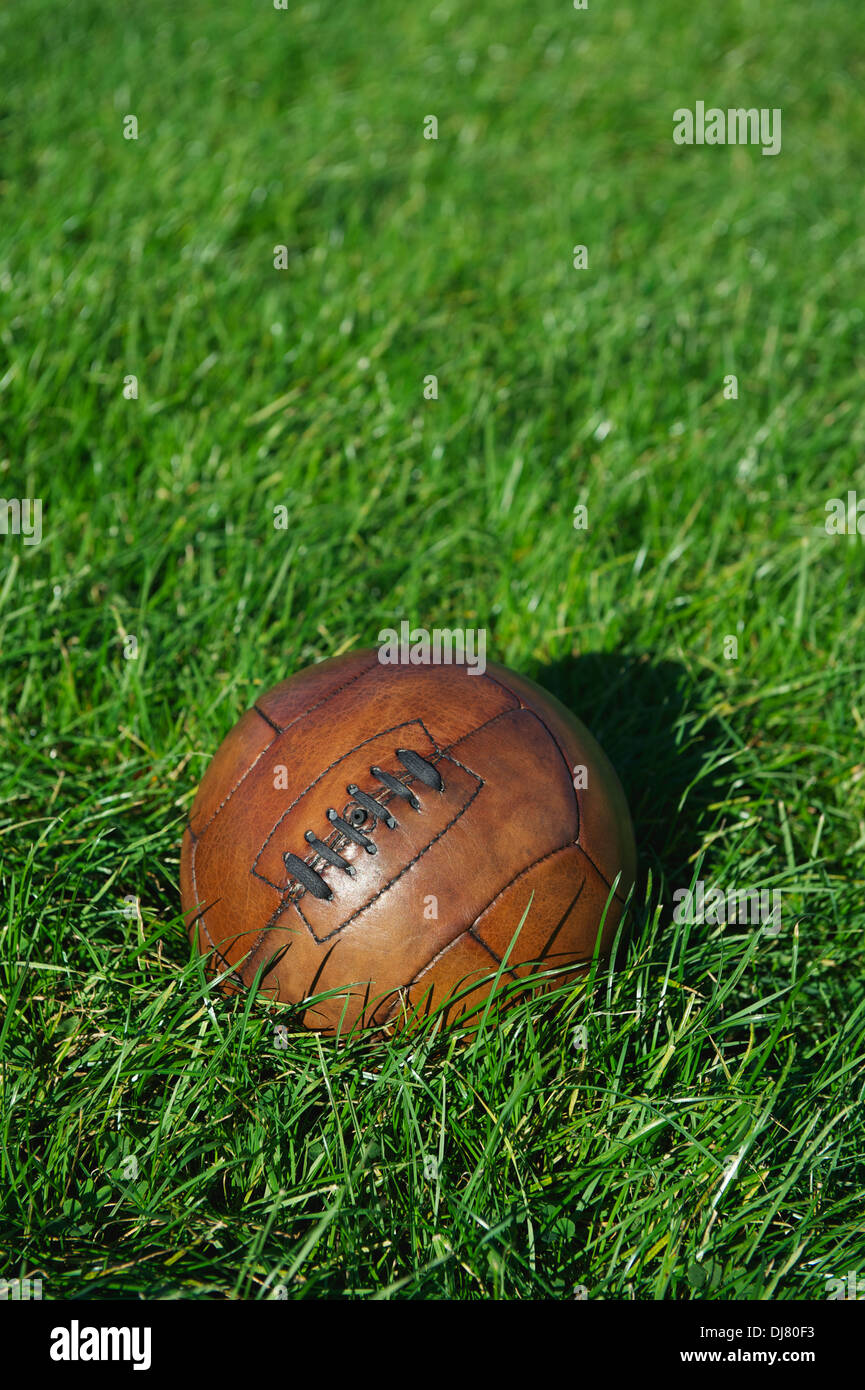 Vintage braun Fußball Fußball sitzt im sonnigen grünen Wiese Stockfoto