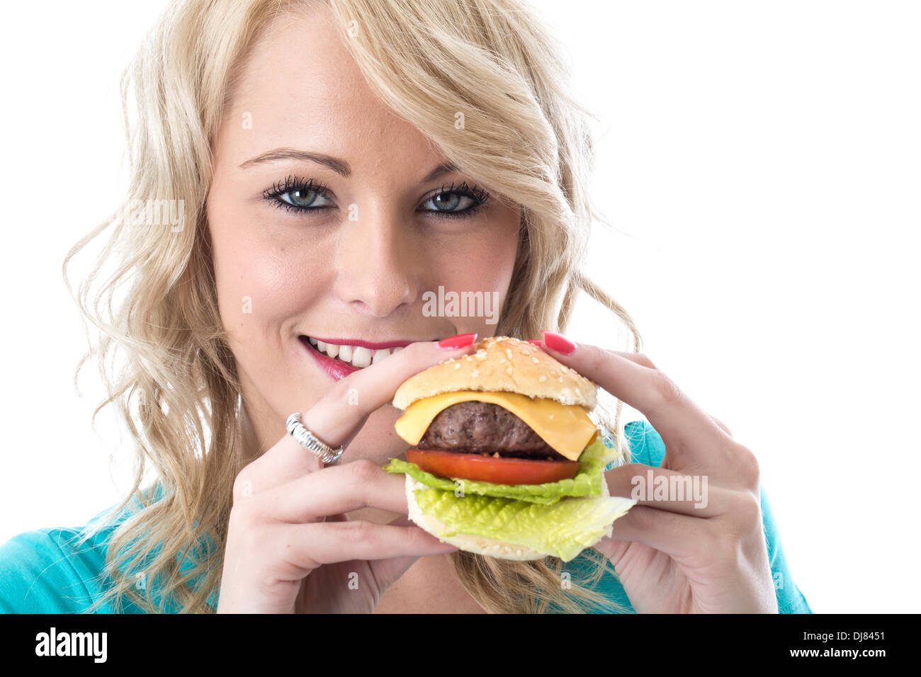 Sicher gerne Positive junge Frau Essen ein Rindfleisch Cheeseburger In einem Brot Brötchen mit Tomate und Salat garnieren Isoliert gegen einen weißen Hintergrund Stockfoto