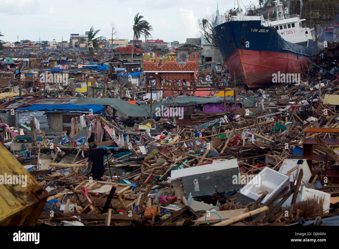 Die große Sturmflut von Taifun Haiyan/Yolanda war so mächtig, Frachtschiffe, verankert in der Nähe wurden einfach aufgehoben, ziehen ihre Anker auf dem Boden Zerkleinern alle Häuser, die darunter lag dann entsorgt. Eine Szene der Verwüstung mit Bewohner Slvaging was sie können. Stockfoto