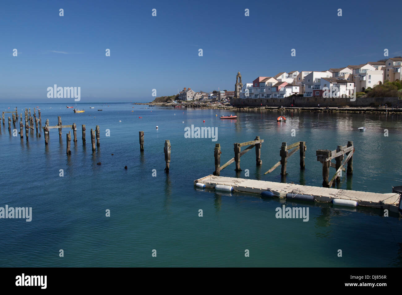 Swanage Bay entlang der Jurassic Coast. Ruhiges Meer und blauer Himmel. Alte Mole im Vordergrund. Häuser am Ufer im Abstand. Stockfoto