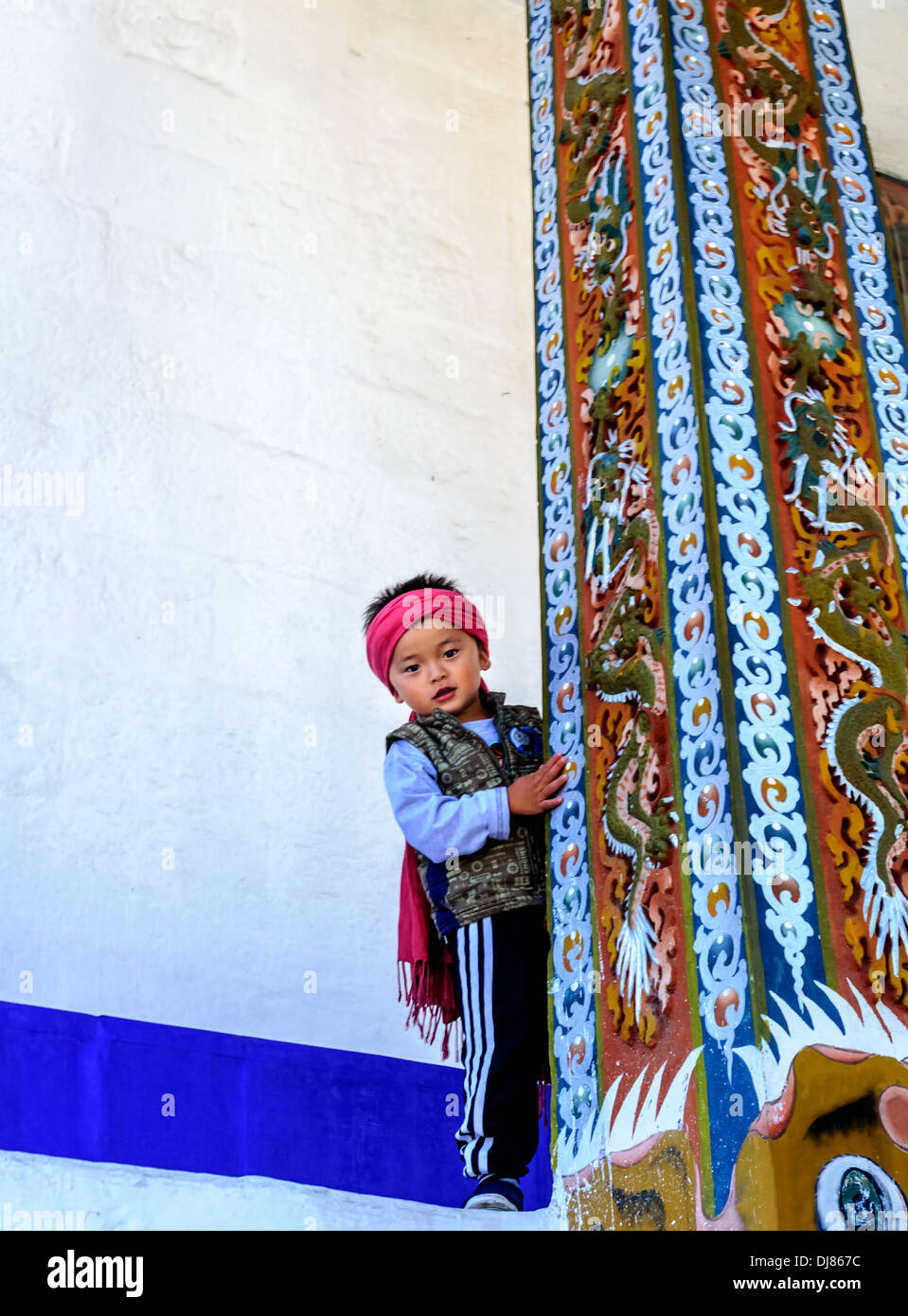 Kleinen bhutanischen Jungen spielen gegen weiße Wand Stockfoto