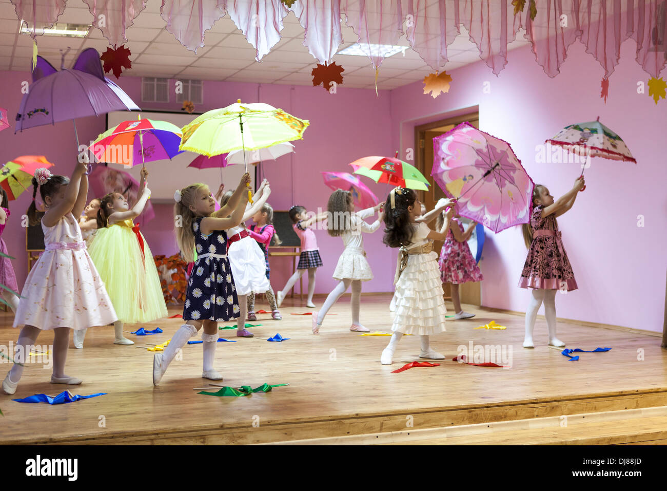 Russische Kinder Kindergarten. Kinder tanzen mit Sonnenschirmen auf der
