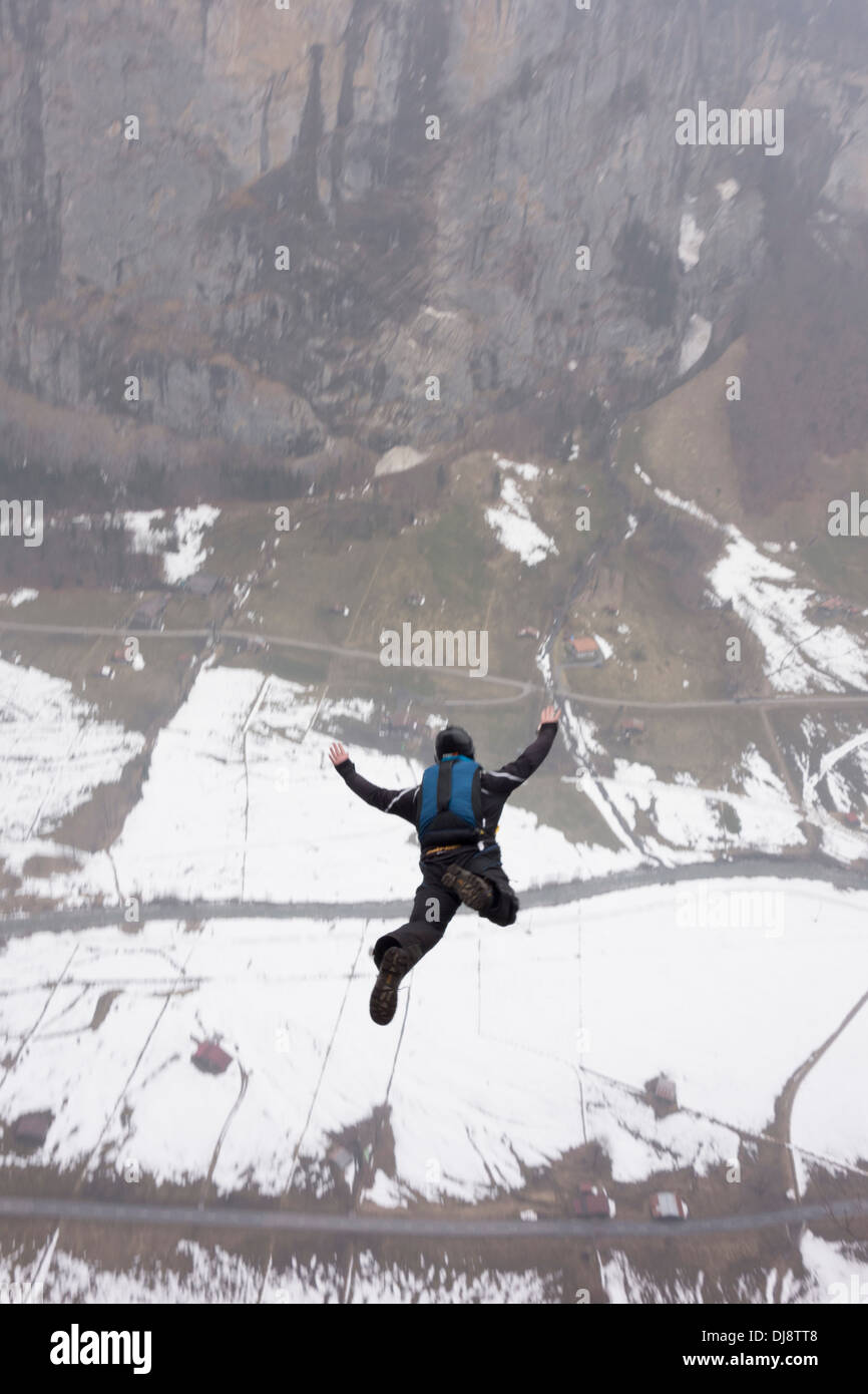 Base-Jumper wird von einer Klippe hinunter in das tiefe Tal beendet. Damit hält er seine Arme sich stabil sein und sparen. Stockfoto