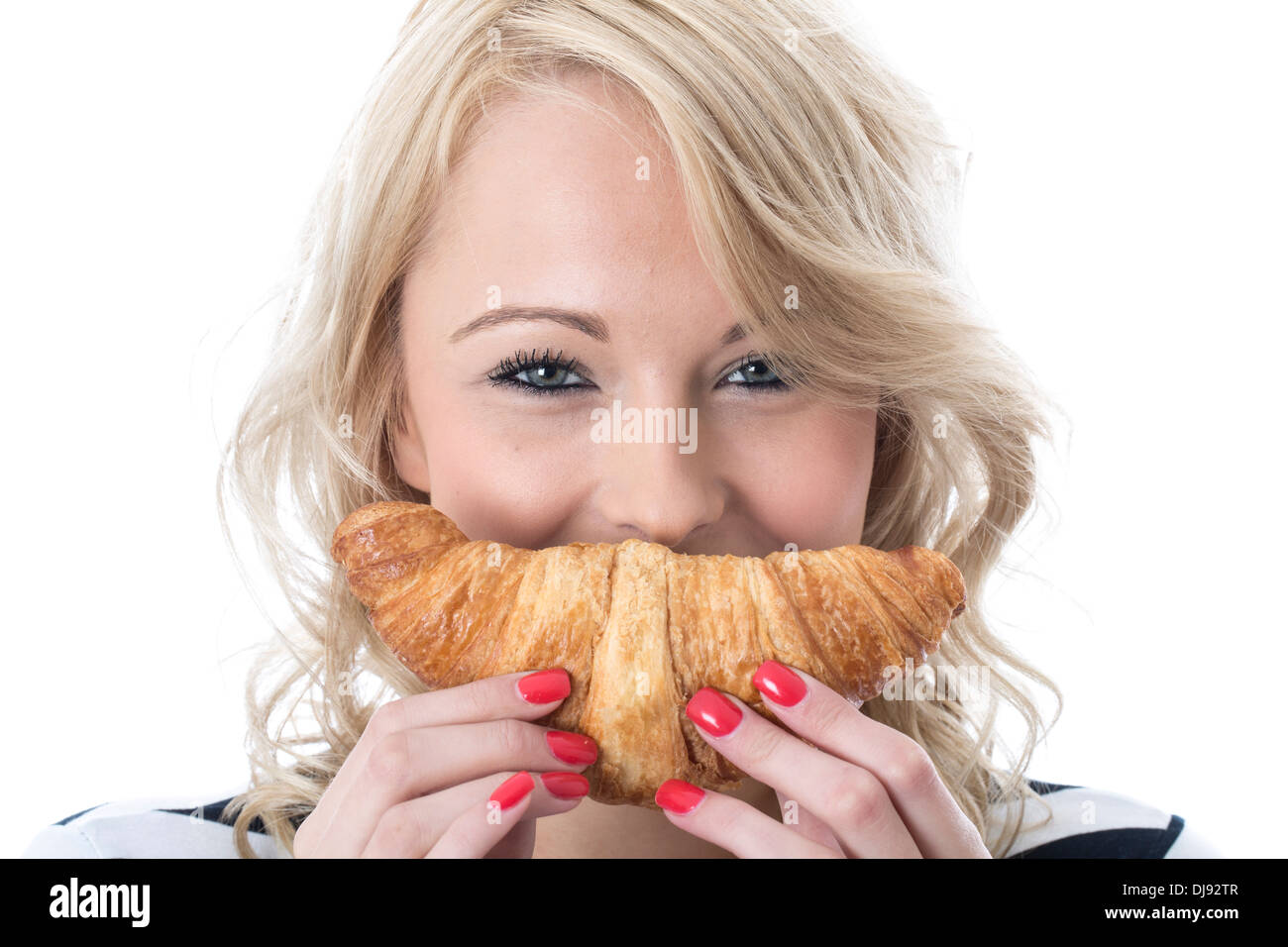 Attraktive Glücklich lächelnde junge Frau mit Essen und Trinken Ein kontinentales Frühstück im französischen Stil gebacken Croissant vor einem weißen Hintergrund Stockfoto