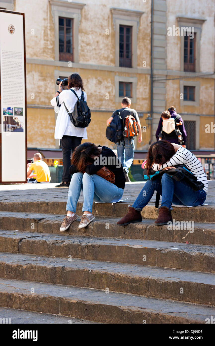 Junge weibliche Touristen mit Köpfen in Runden, ruht auf Schritte, wie andere, Florenz, Italien fotografieren Stockfoto