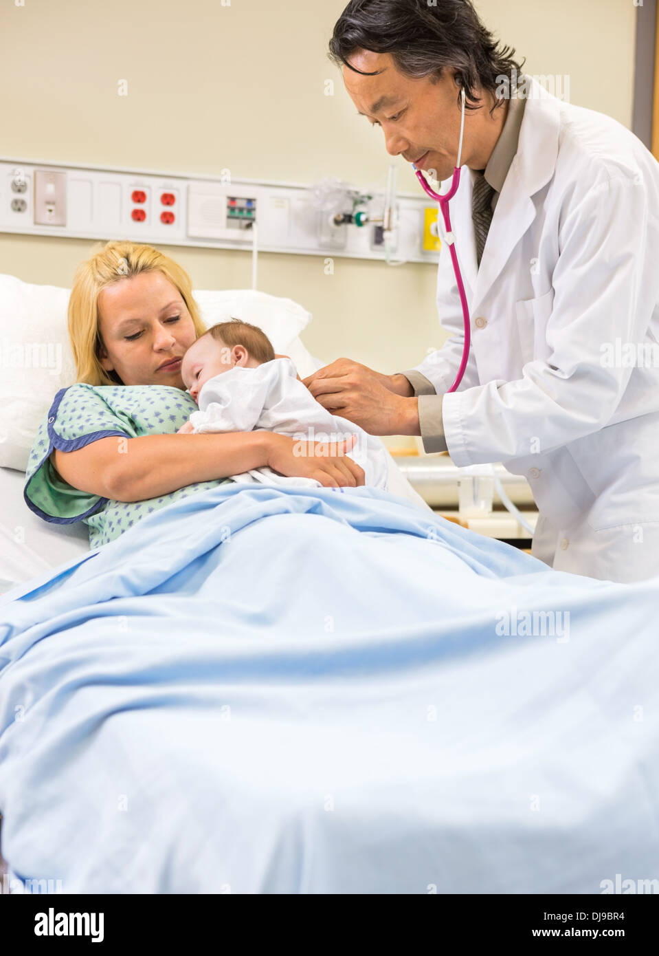 Arzt untersuchen Babygirl In Mutters Armen schlafen Stockfoto