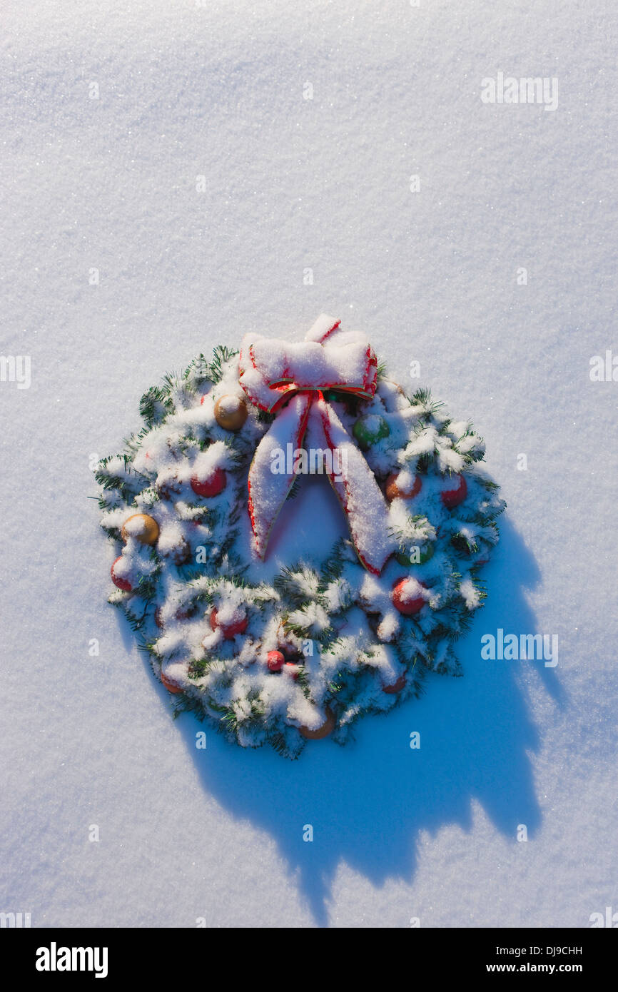 Adventskranz mit einer roten Schleife und bunte Lichter im Schnee In Alaska Fairbanks liegen Stockfoto