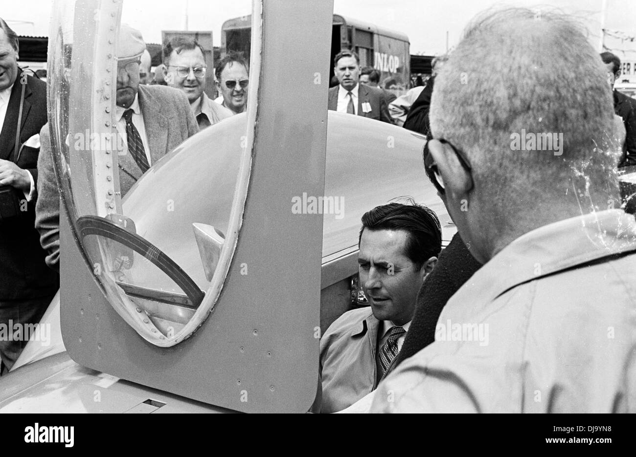 Jack Brabham versuchen Campbells Bluebird Cockpit für Größe. Pre-Mitgliederversammlung, Goodwood, England 19. März 1960. Stockfoto