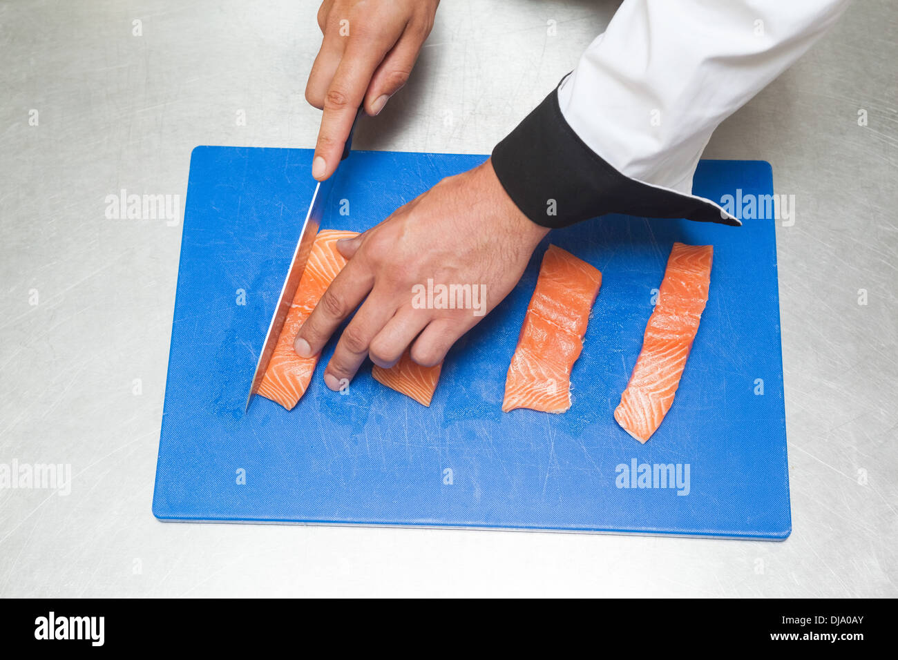 Koch rohen Lachs mit scharfen Messer schneiden Stockfoto