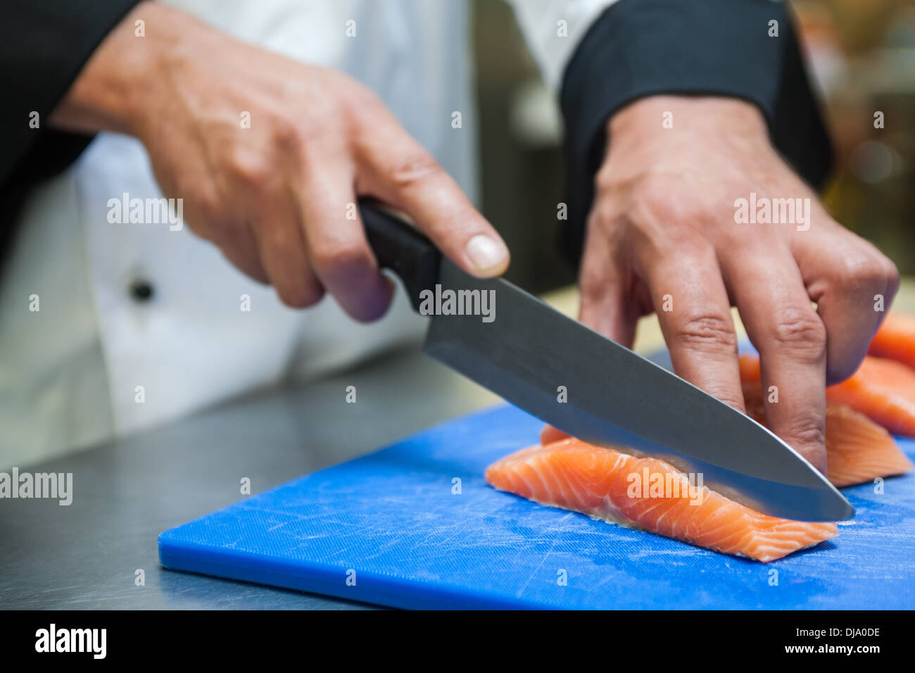 Nahaufnahme von Küchenchef Lachs mit scharfen Messer schneiden Stockfoto