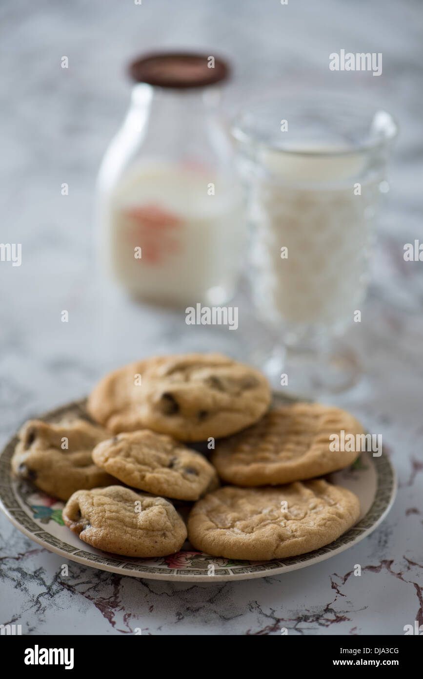 Kekse und Milchschokolade-Chip-Kekse mit einem Glas Milch. Stockfoto