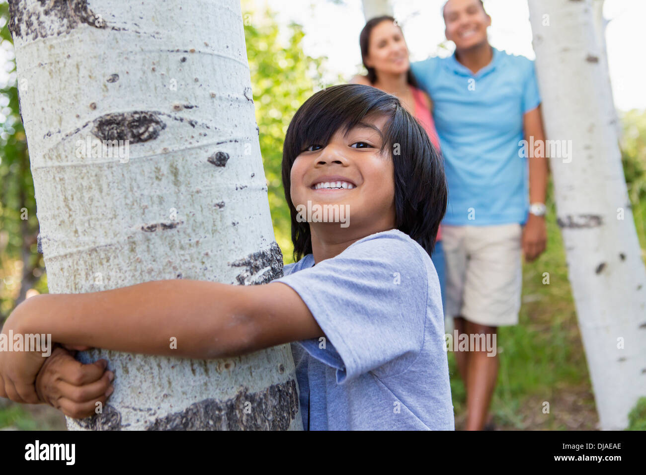 Junge umarmt Baum im freien Stockfoto