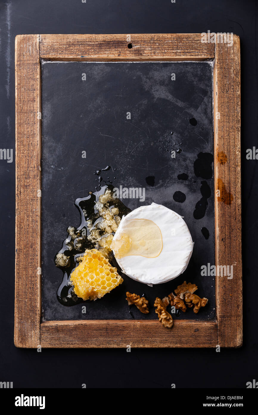 Käse mit Honig und Nüssen an Vintage Schiefer Tafel Stockfoto