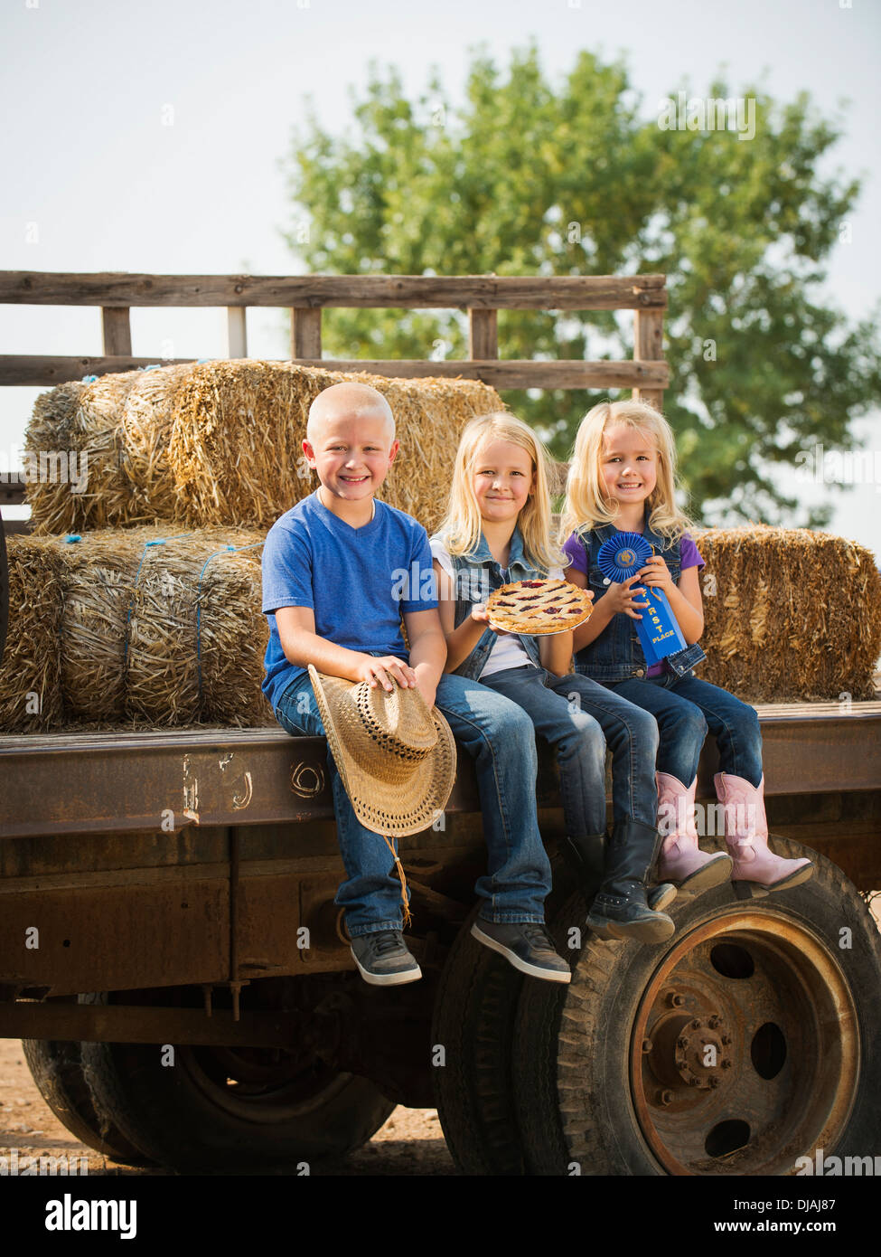 Kaukasische Kinder sitzen auf LKW auf Bauernhof Stockfoto