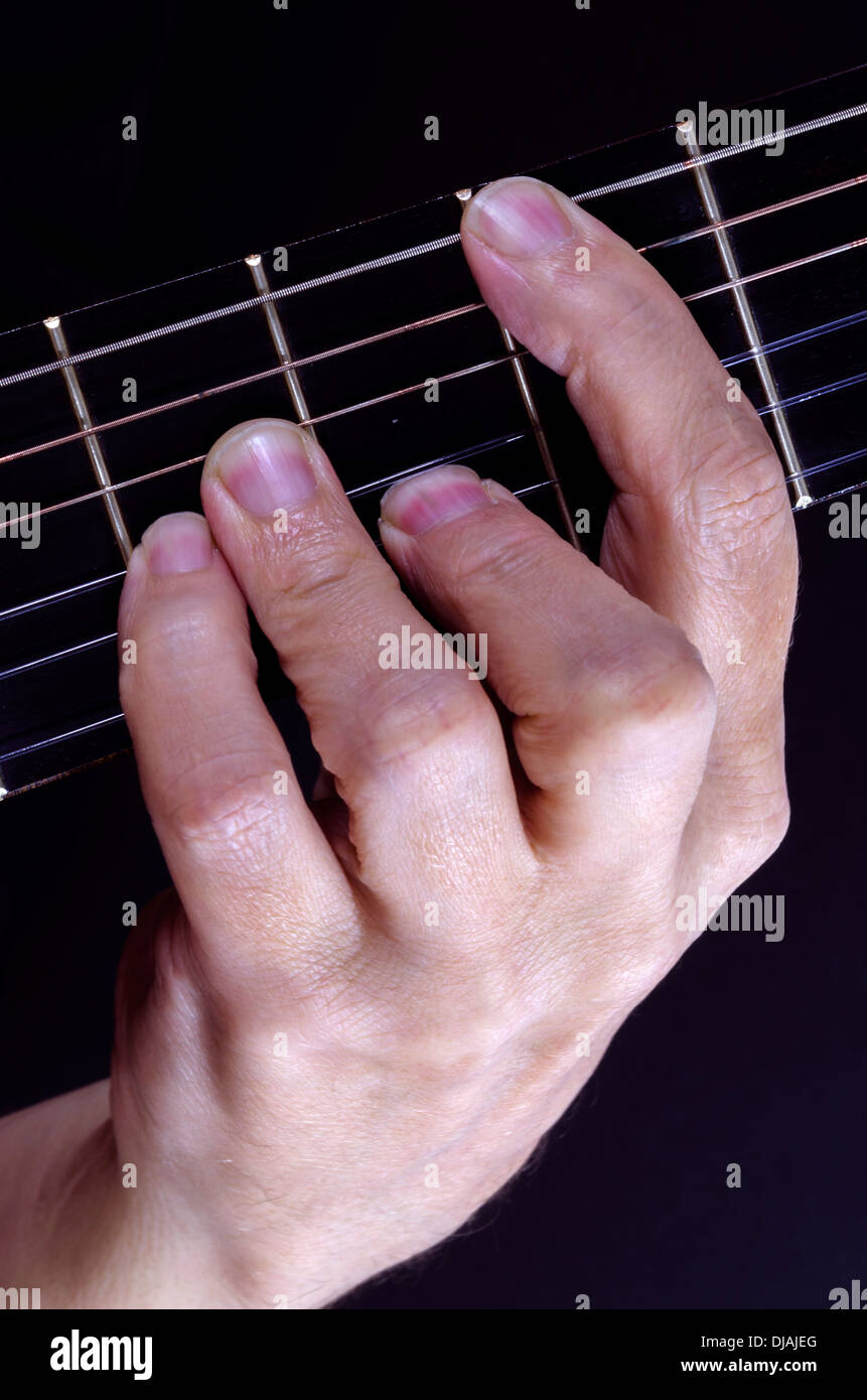 Nahaufnahme des Gitarristen halten Sie einen Akkord auf dem Griffbrett Stockfoto