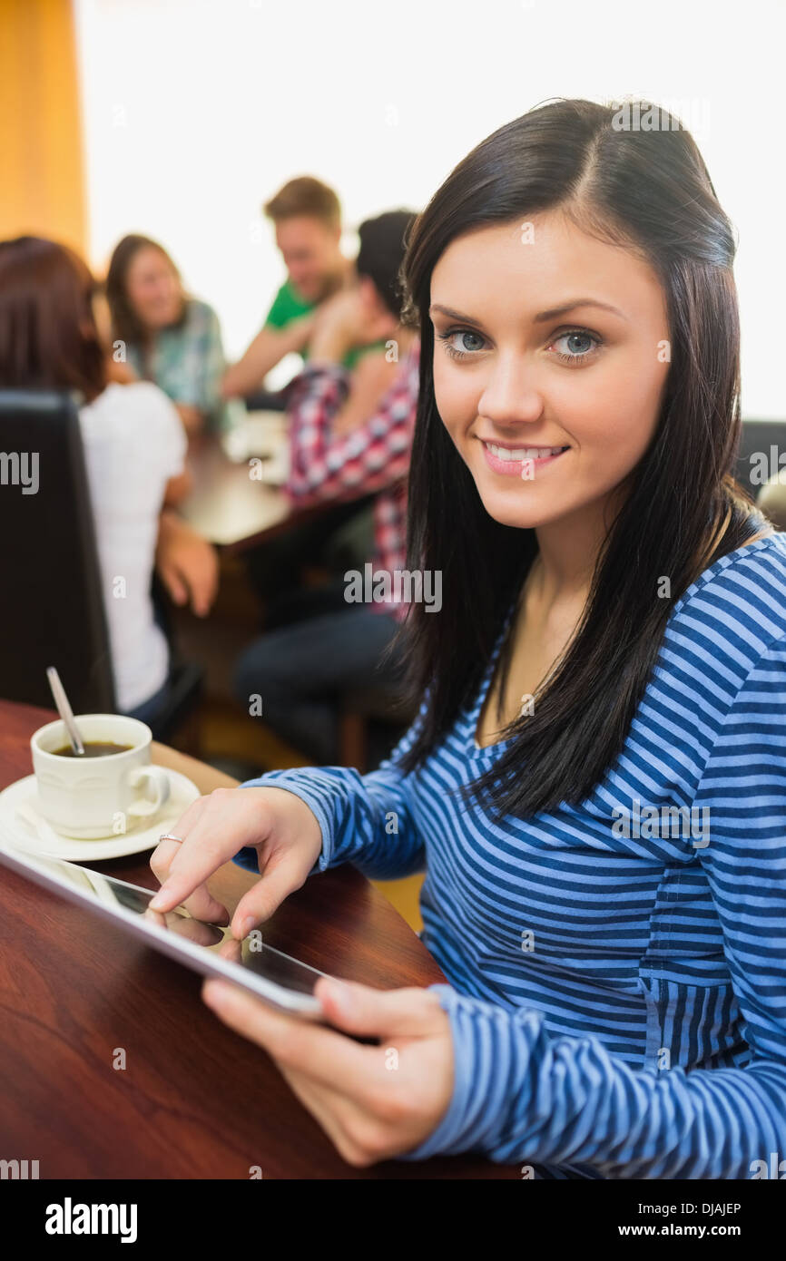 Weibchen mit Kaffee mit Tablet-PC in der Cafeteria Stockfoto