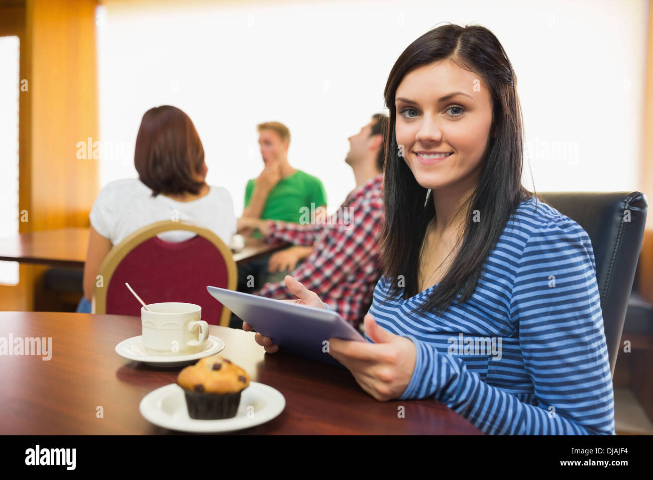 Lächelnde Frau frühstücken mit Tablet-PC im Coffee shop Stockfoto