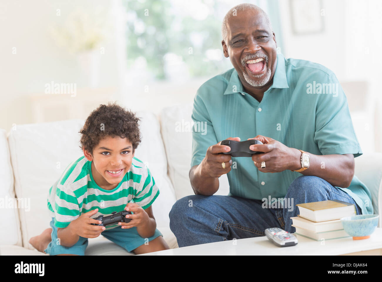 Jungen spielen von Videospielen mit Großvater Stockfoto