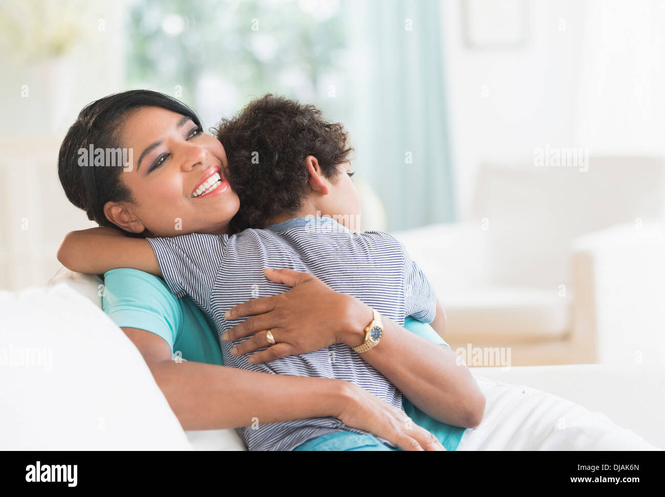 Mutter umarmt Sohn auf sofa Stockfoto