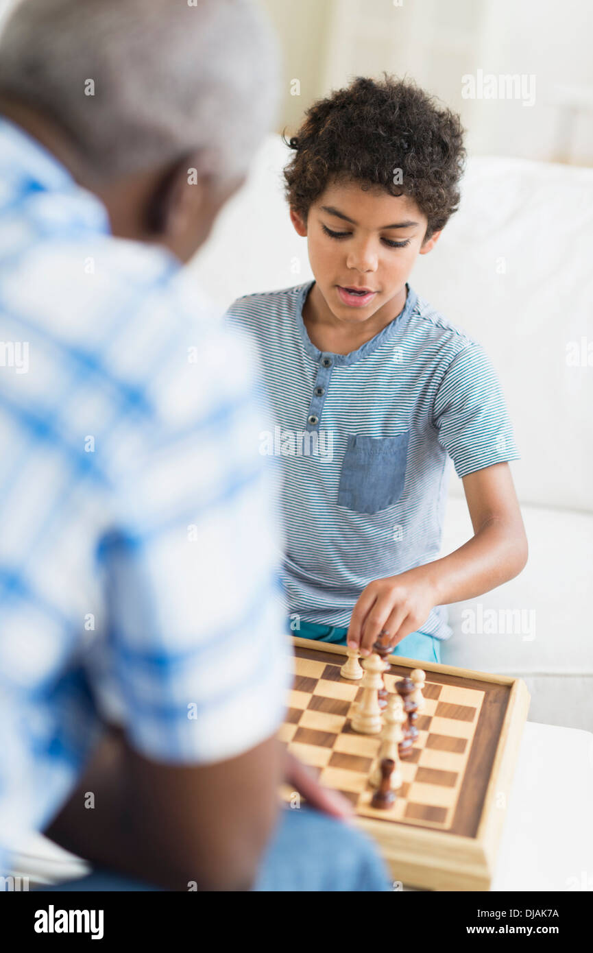 Junge spielt Schach mit Großvater Stockfoto