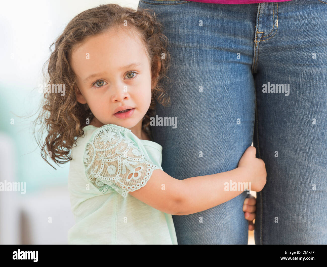 Gemischte Rassen Mädchen klammerte sich an Mutters Bein Stockfoto