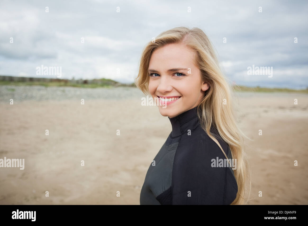 Schöne Frau im Neoprenanzug am Strand Stockfoto