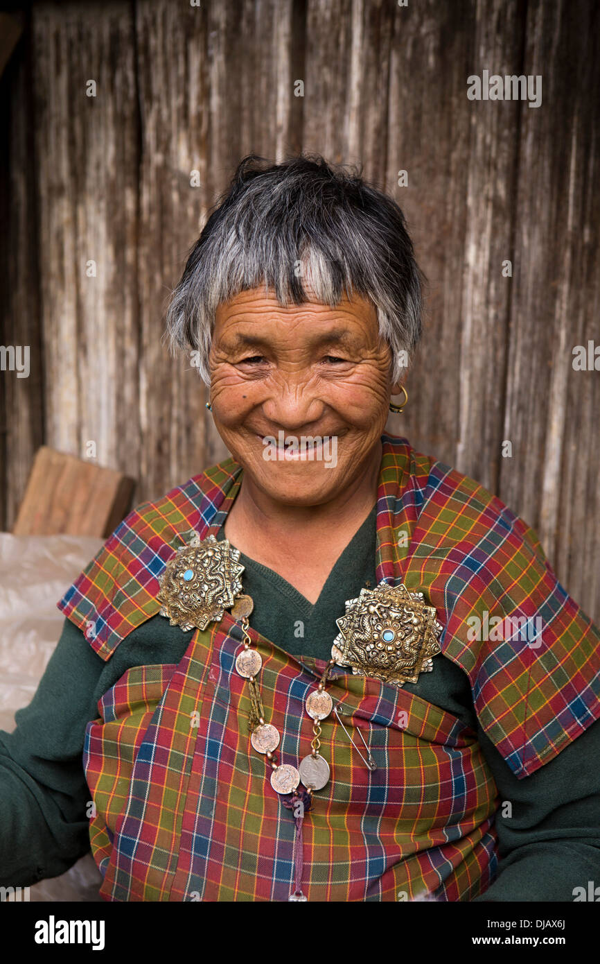 Bhutan, Nobding, lächelnde Frau in traditionellen Kira mit alten silbernen Korma Brosche Stockfoto