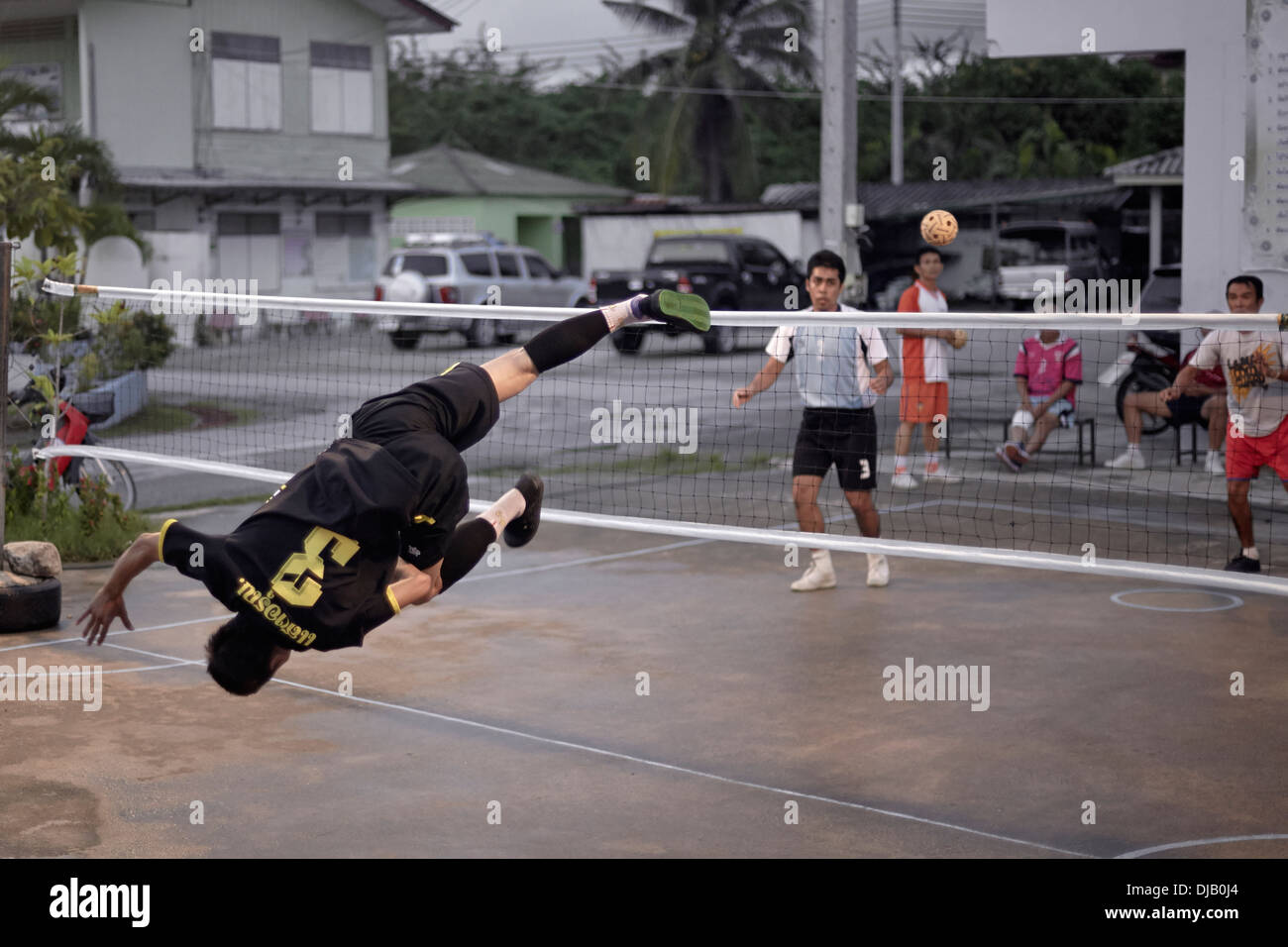 Extreme Sportlichkeit während eines Spiels von Sepak Takraw. Traditionelle und beliebte thailändische Fußballspiel. S. E. Asien Thailand Stockfoto