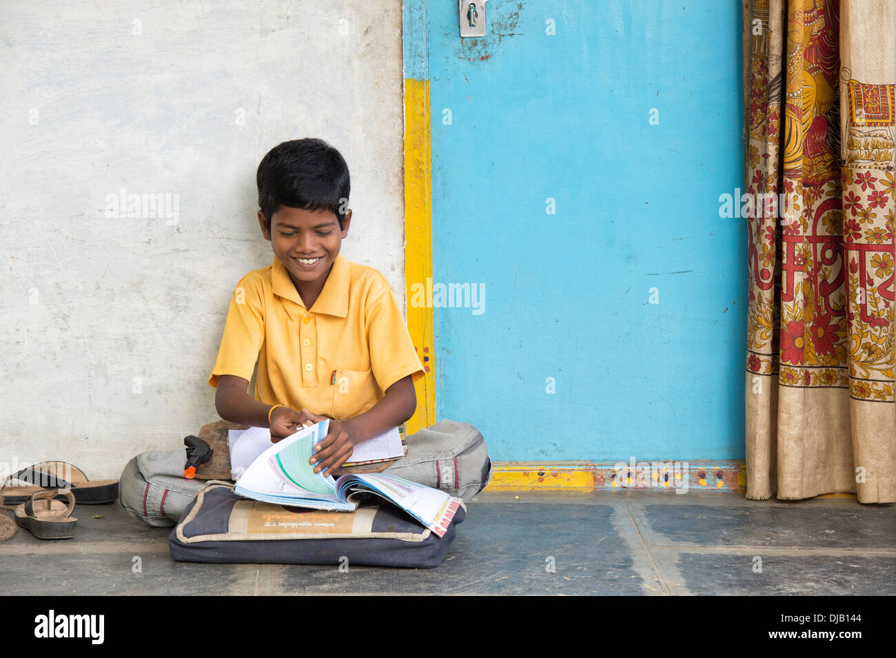 Indische Junge Schule Arbeit außerhalb seiner ländlichen Heimat Indianerdorf. Andhra Pradesh, Indien Stockfoto