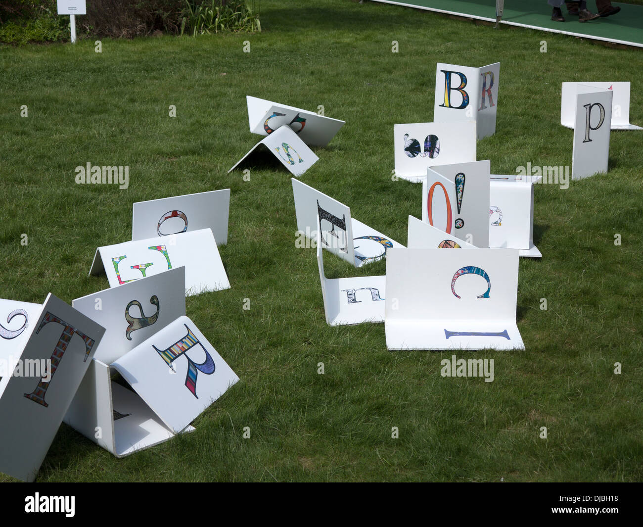 Zufällige Buchstaben verbreiten nach dem Zufallsprinzip auf Rasen durcheinander Stockfoto