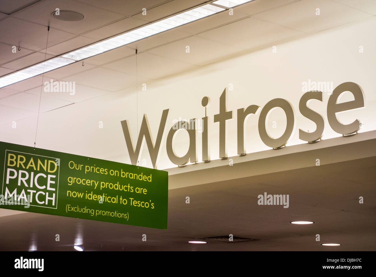 Waitrose und ihre Marke Preis Match Versprechen unterzeichnen Display im Store, UK Stockfoto