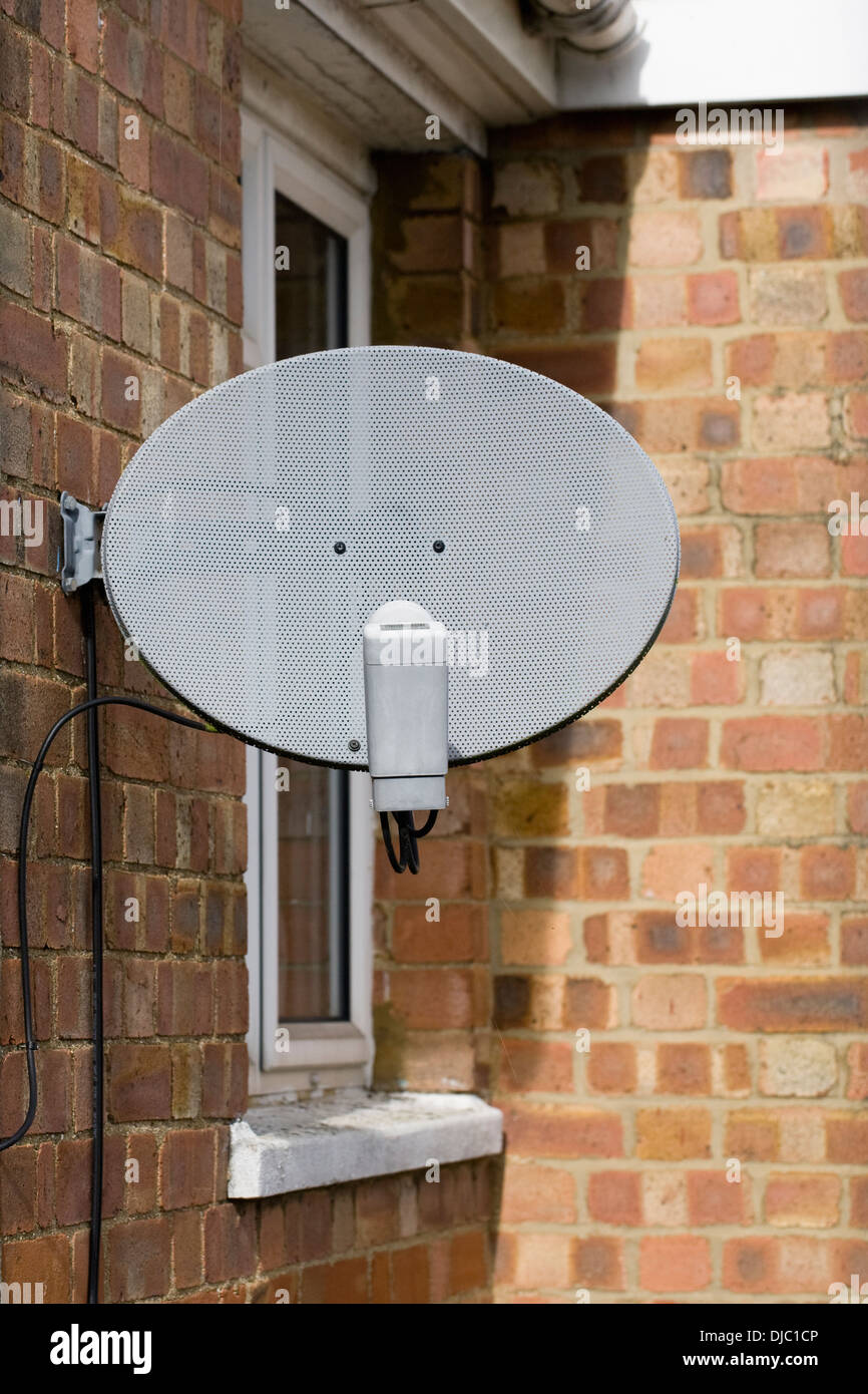 TV-Sat-Antenne an der Seite eines UK-Hauses befestigt. Stockfoto