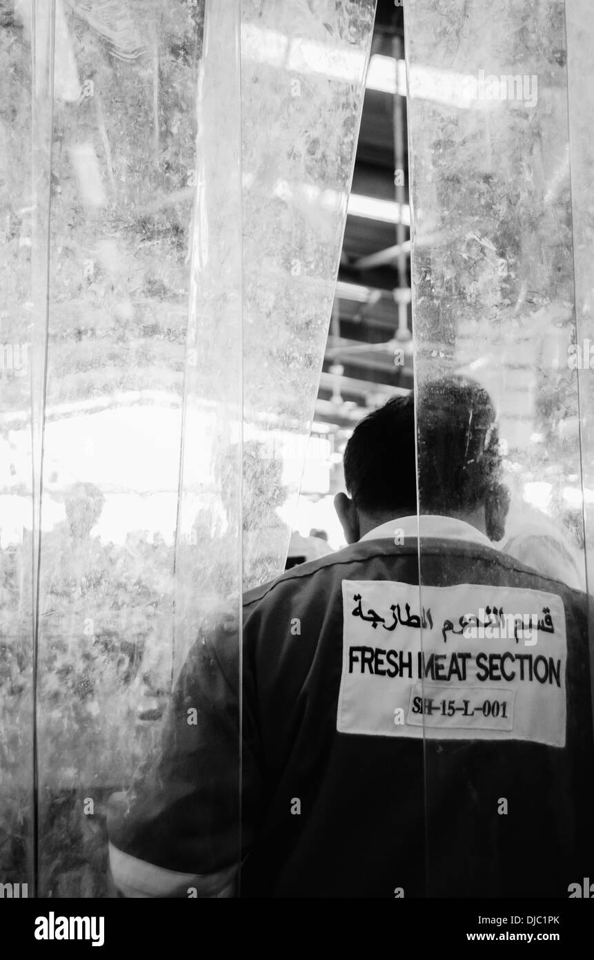 Arbeiter vor Kunststoff Schutzvorhänge in Deira Fleischmarkt. Dubai, Vereinigte Arabische Emirate. Stockfoto