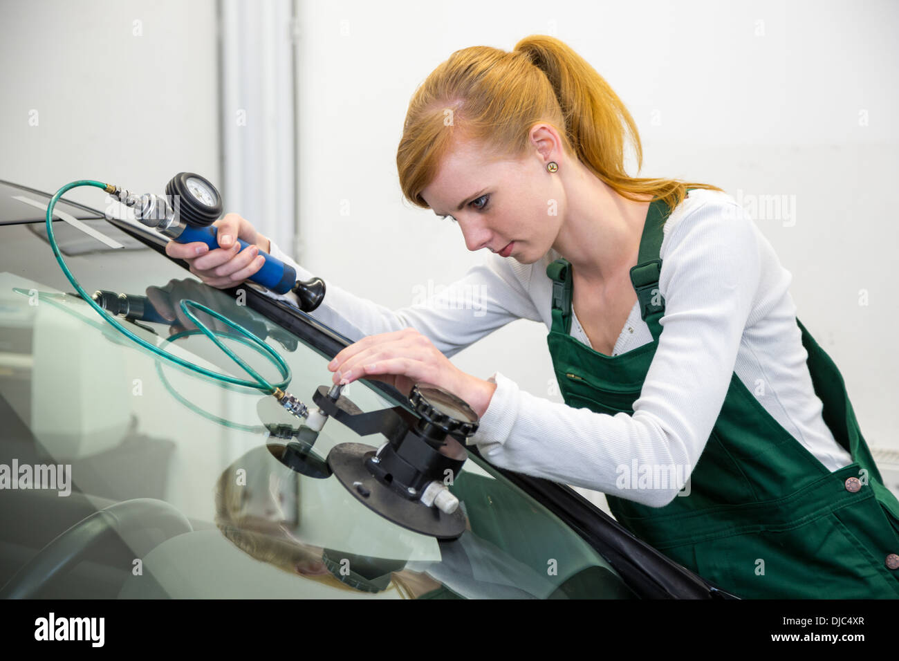 Windschutzscheibenreparatur von Glaser in Garage nach Steinschlag-Schäden Stockfoto