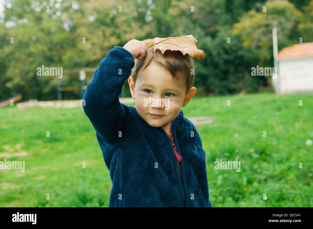 Kleiner Junge hält Blatt auf seinem Kopf Stockfoto