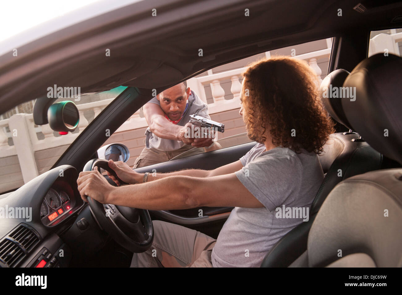 Mann immer Carjacked mit vorgehaltener Waffe. Stockfoto