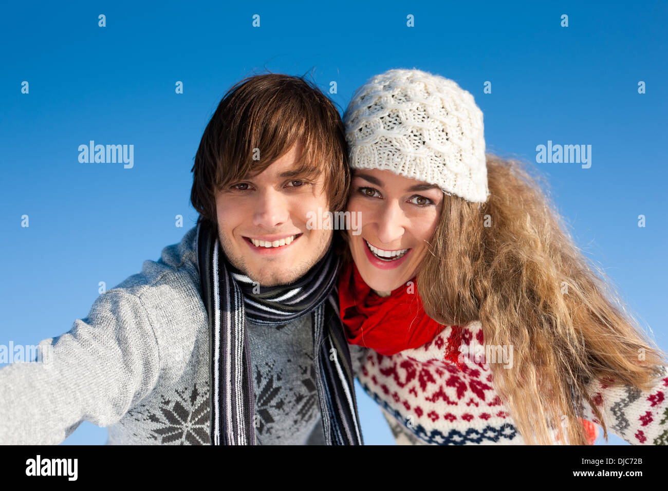 Paar - Mann und Frau - mit einem Winterspaziergang; Er trägt Sie Stockfoto