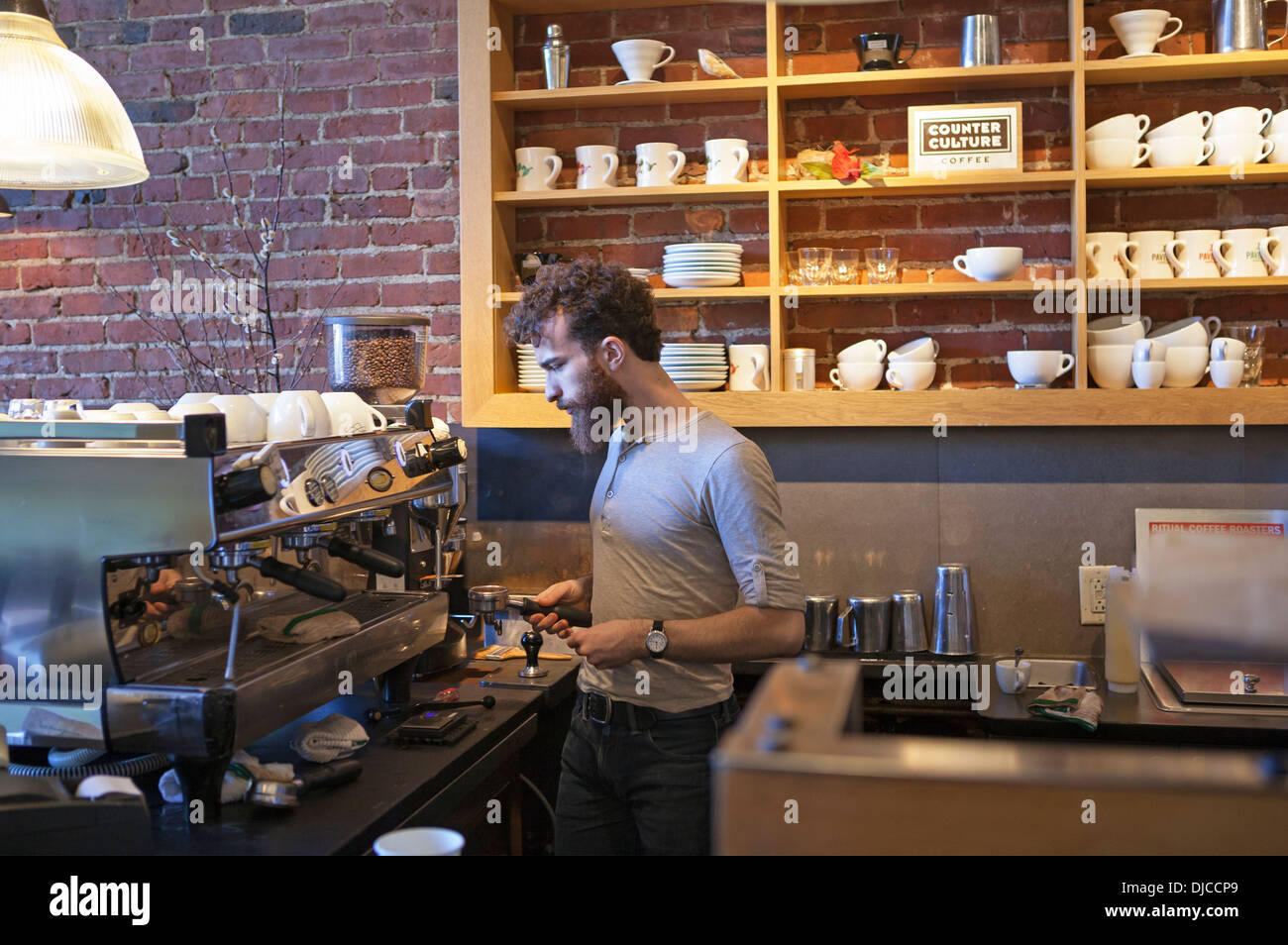 Ein Barista sorgt dafür, dass der Kaffee in einem Café in Boston, Massachusetts, USA, gut schmeckt. Stockfoto