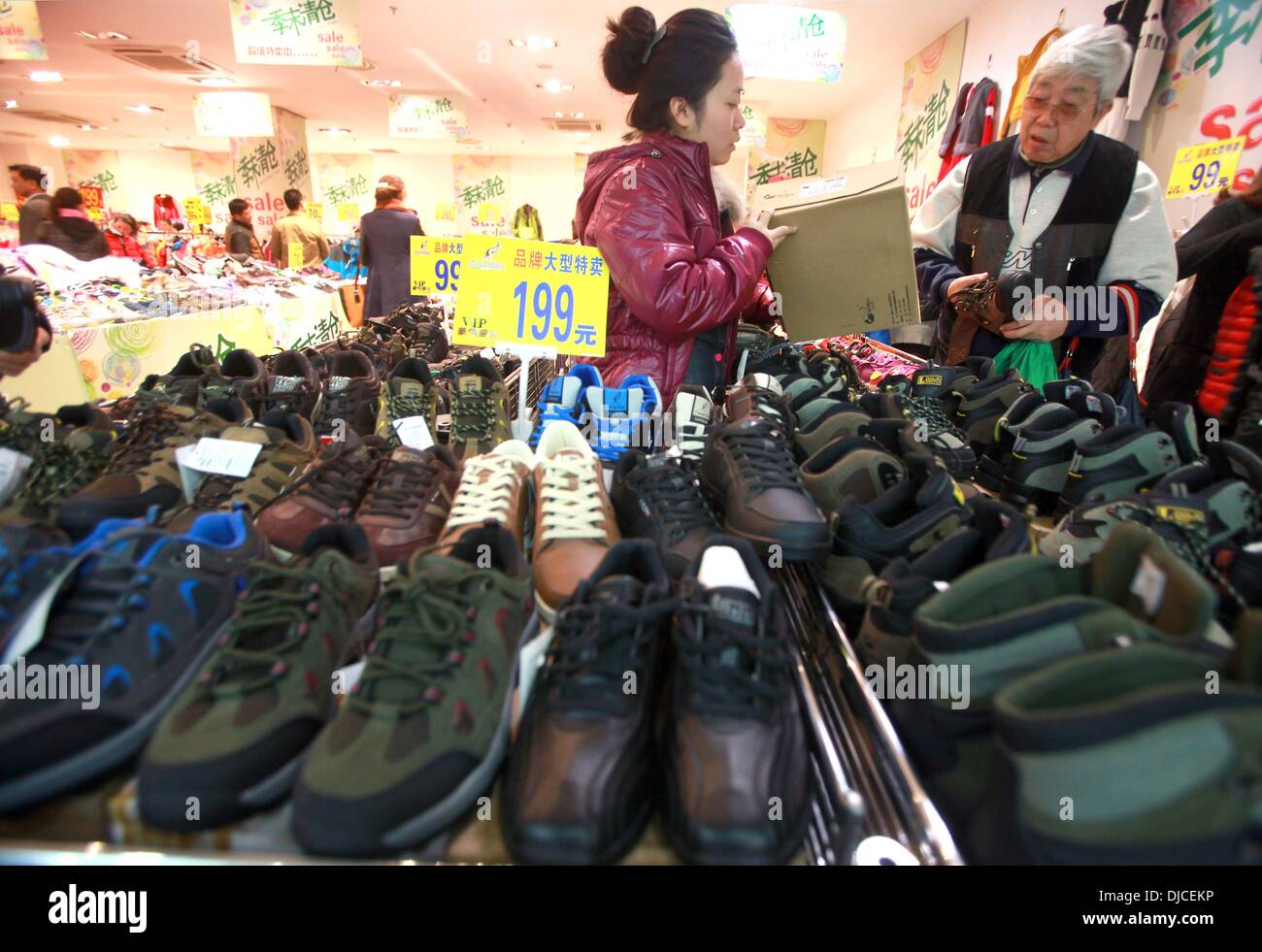 Eine chinesische Verkäuferin hilft ein Kunde an einem Schuh stand, wo ein paar Schuhe USA Kosten. 11. November 2013. $15 am meisten, in einem Einkaufszentrum im Zentrum von Peking am 11. November 2013. Eine neue bundesweite Umfrage unterstreicht das zunehmende Gefälle zwischen Chinas und Besitzlosen, darauf hinweist, dass die Wirtschaft ihre aktuellen Verlangsamung mit breiten Wirtschaftsgefälle plagen das Land weiterhin eingegeben. Stephen Shaver/ZUMAPRESS.com/Alamy © Live-Nachrichten Stockfoto