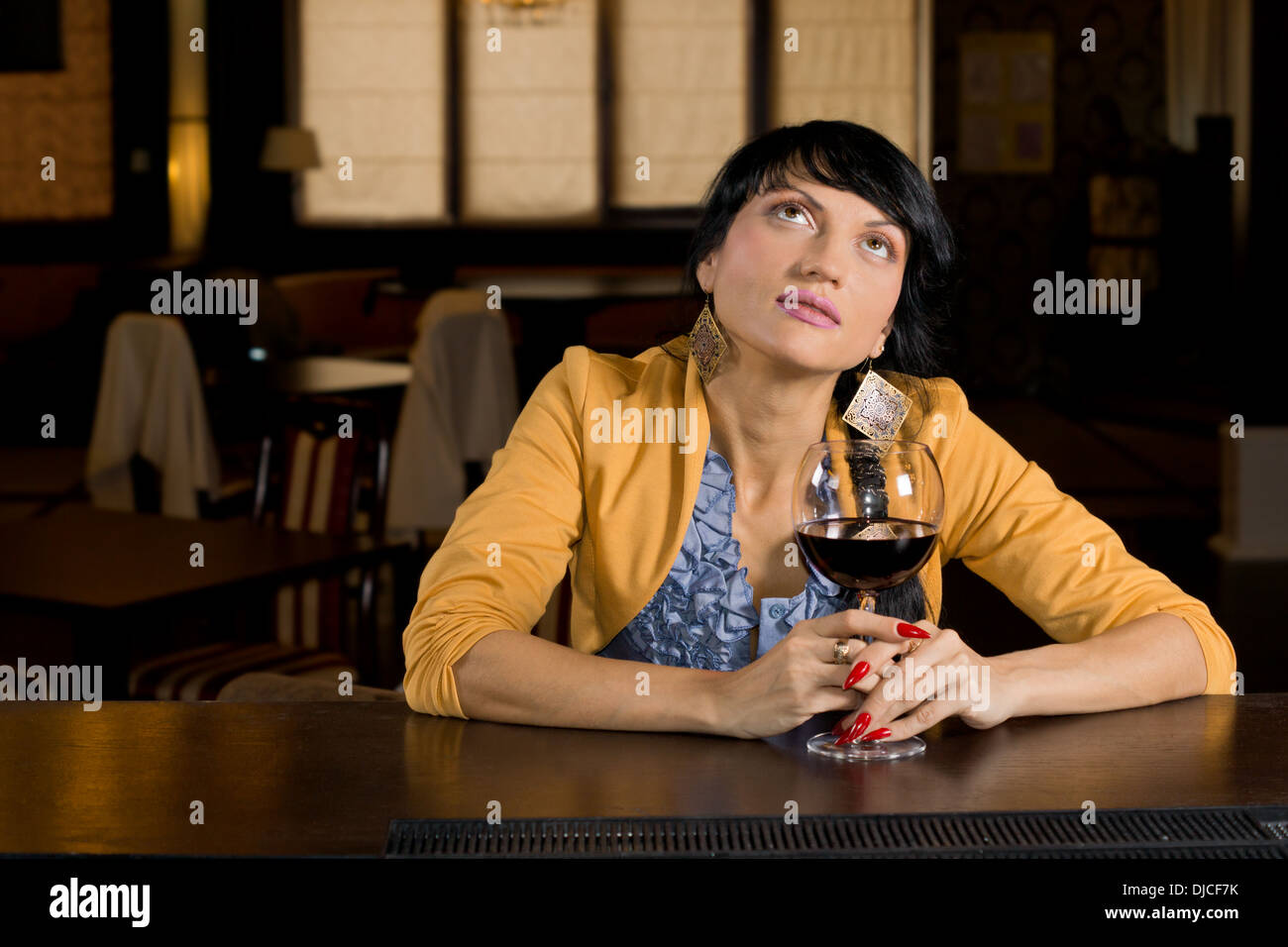 Nachdenkliche Frau trinken Rotwein an der Bar sitzt starrte in die Luft, wie sie erinnert oder träumt Stockfoto