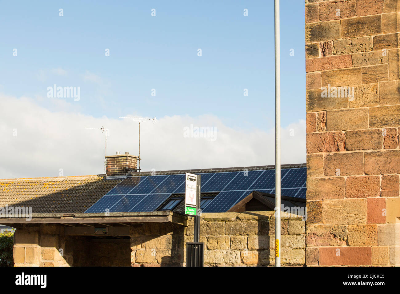 Schlecht positionierte Sonnenkollektoren auf einem Hausdach in Alnmouth, Northumberland, die vollständig über die Schatten Stockfoto